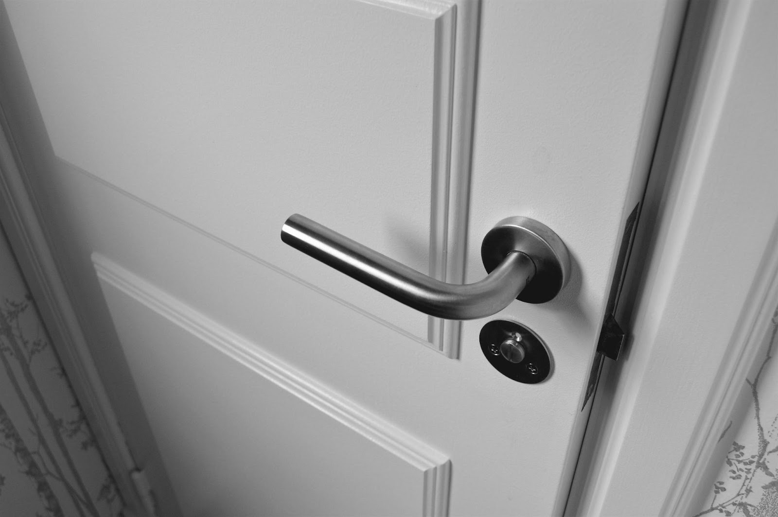 close up view of white door with metal handle