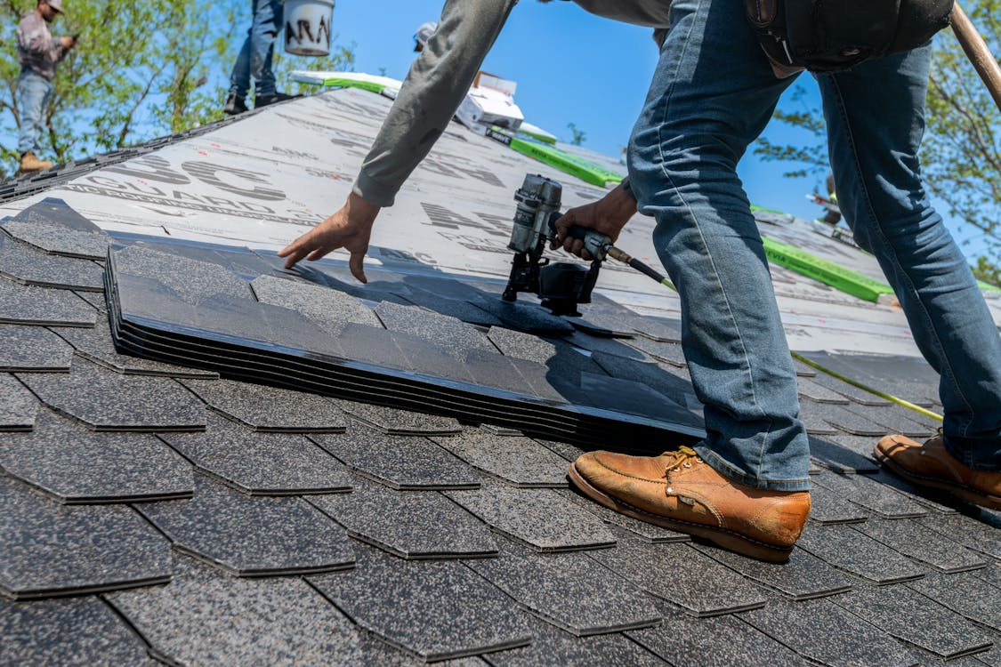 man on roof working on roof tiles