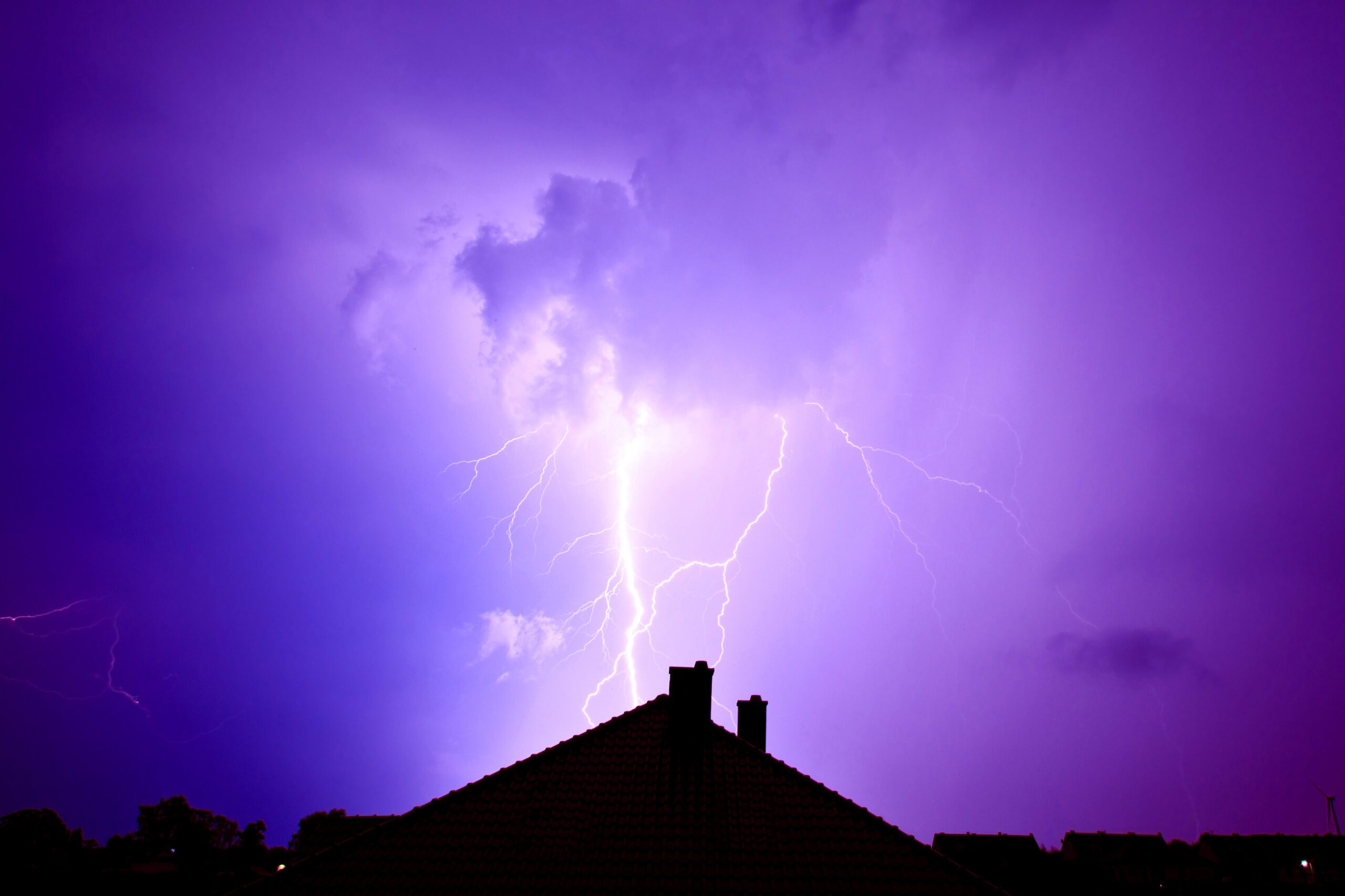 lightning hitting house with purple sky