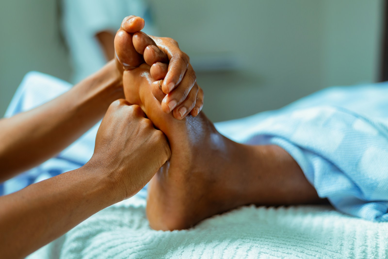 a person laying in a bed with their feet up, being massaged