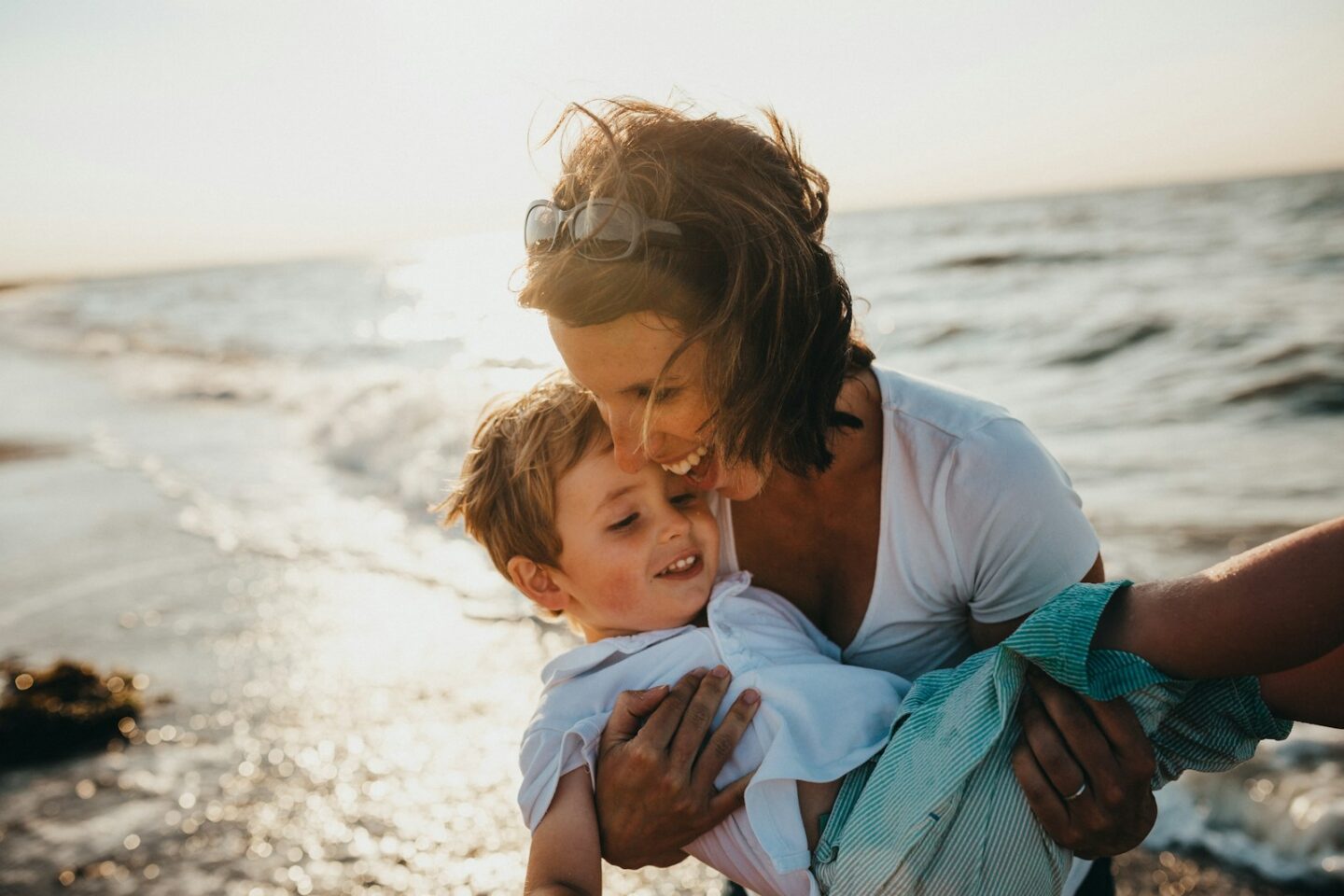 photo of mother and child beside the sea