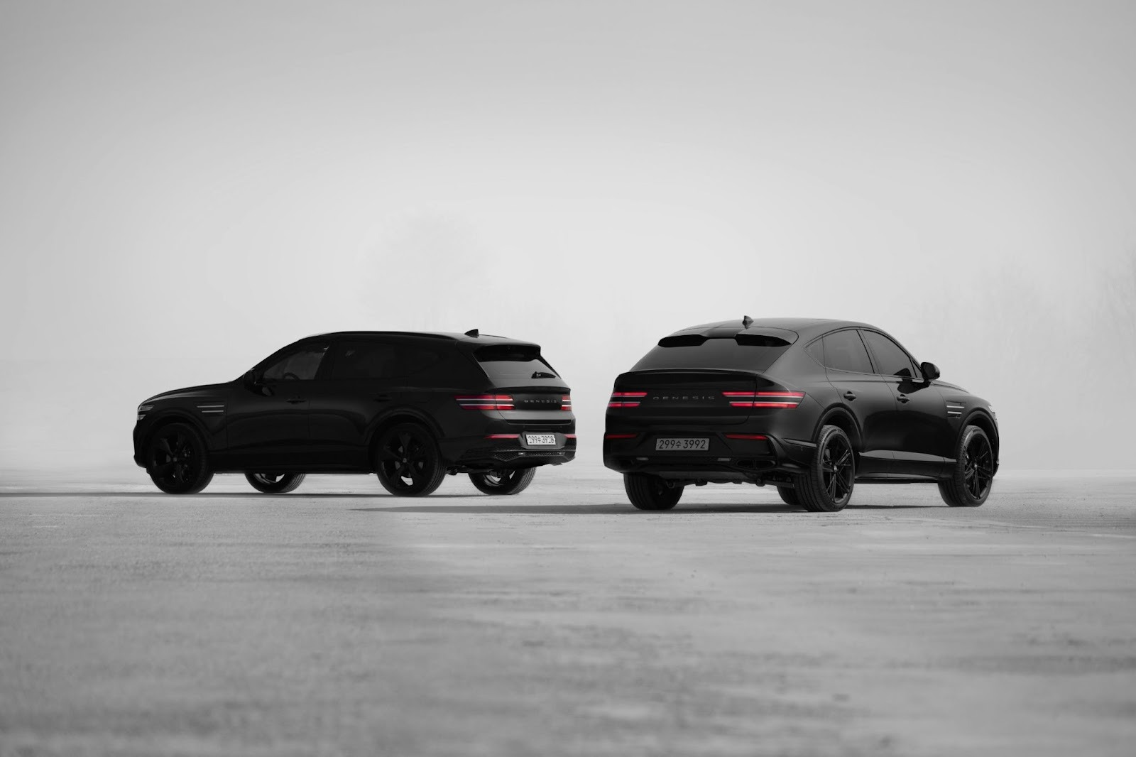 black and white shot of two black cars facign away from camera