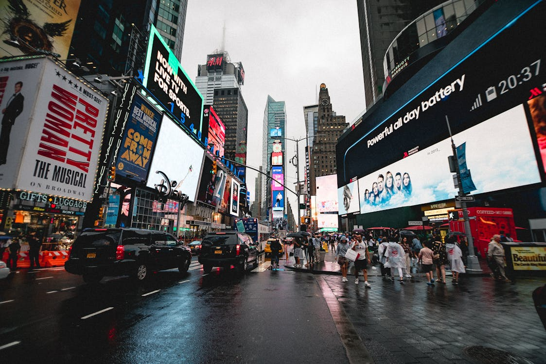 times square in new york with lit up billboards and lots of people