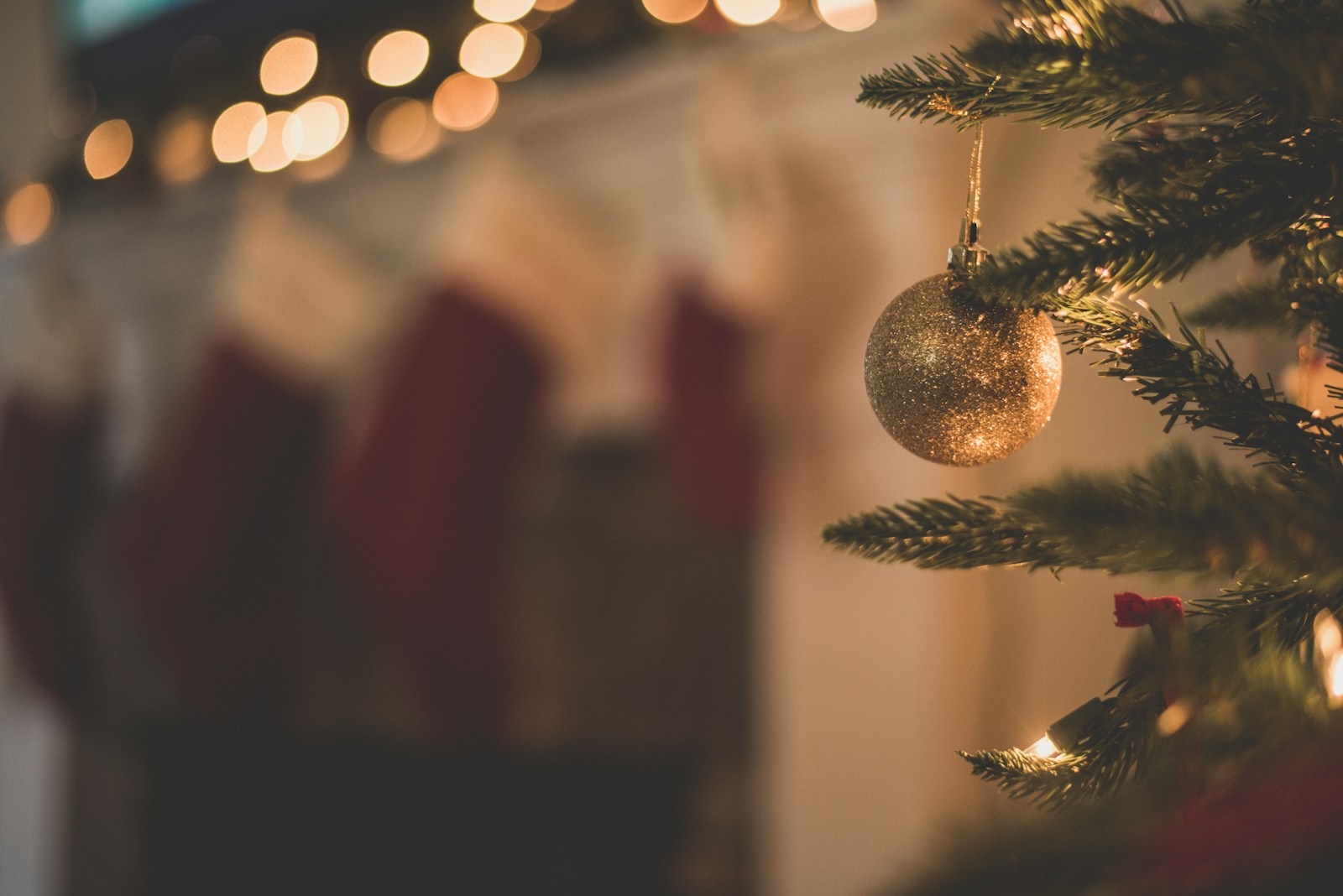 closeup photo of baubles on christmas tree and stockings in the background