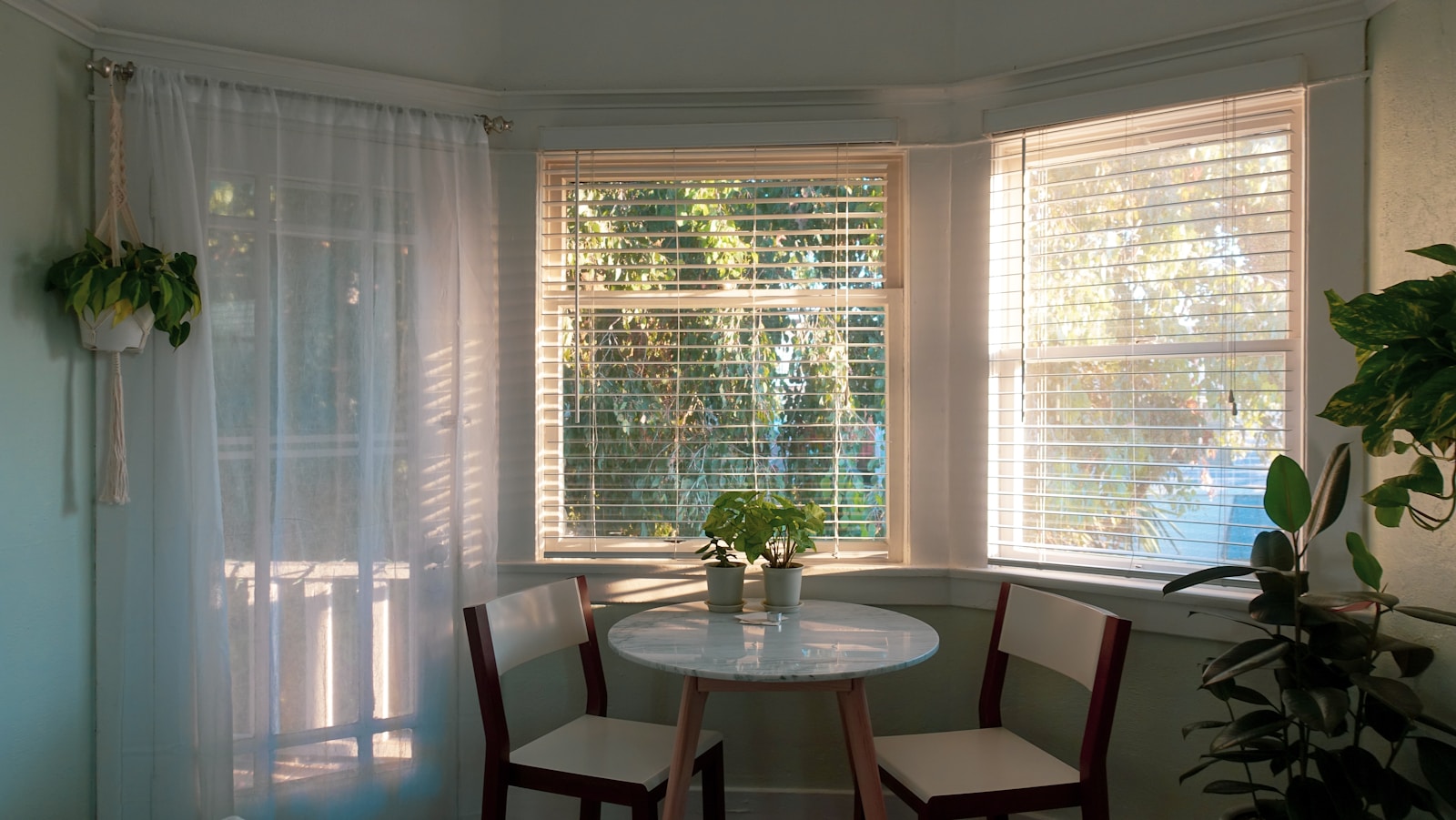 table and chairs in front of window with blinds in home