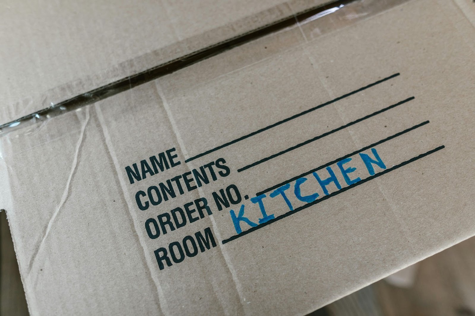 cardboard box with 'kitchen' written on it