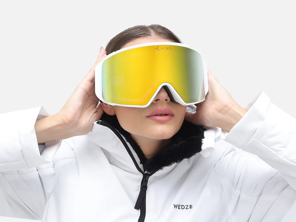 woman in ski goggles and white ski jacket