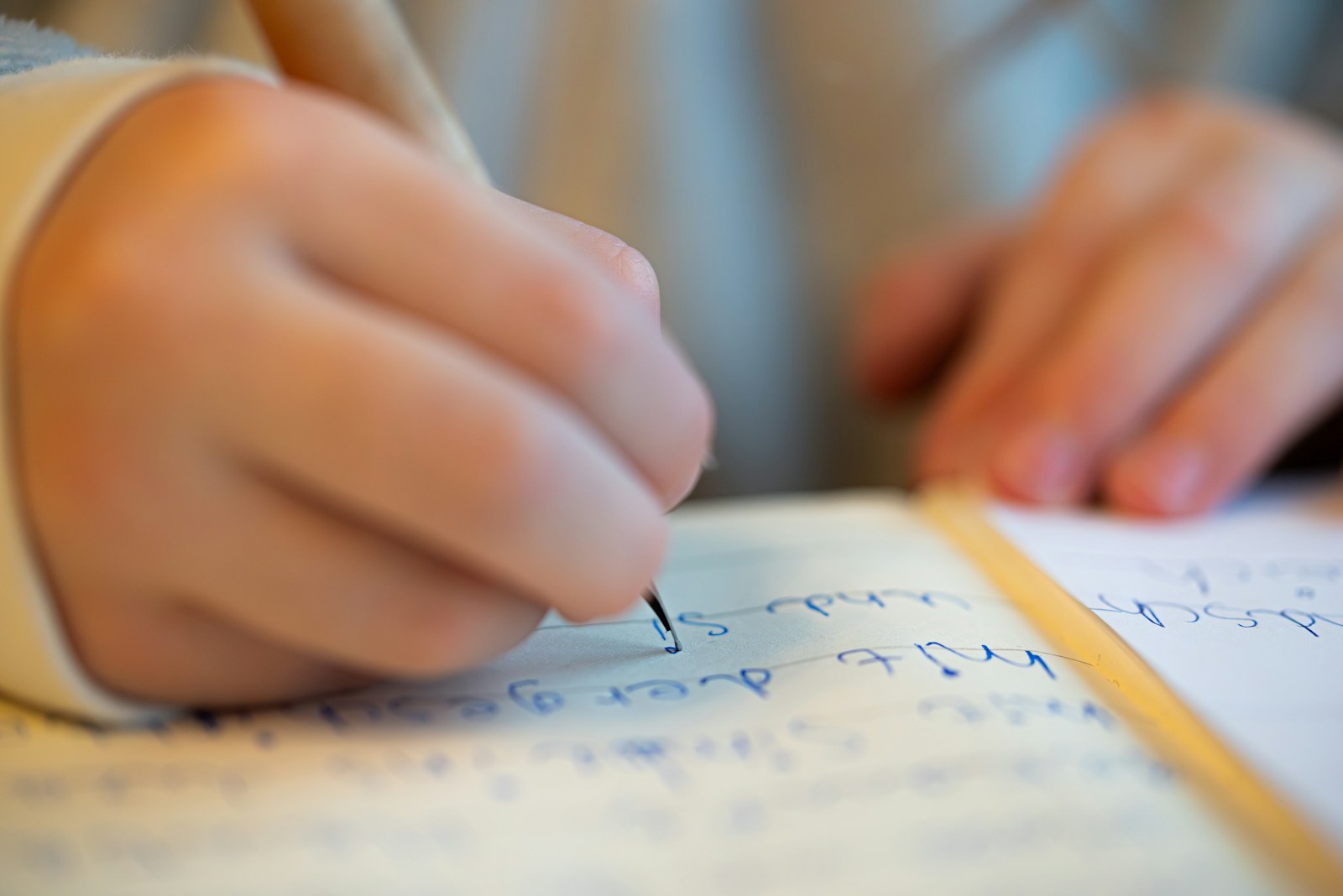 a child doing homework with a pencil up close