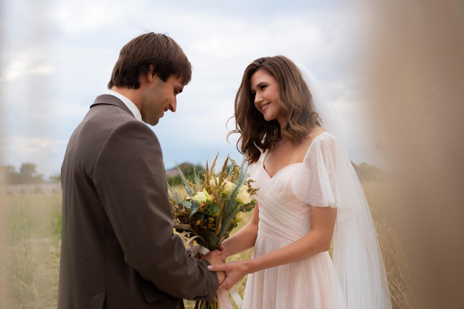 bride and groom holding hands at altar and smiling