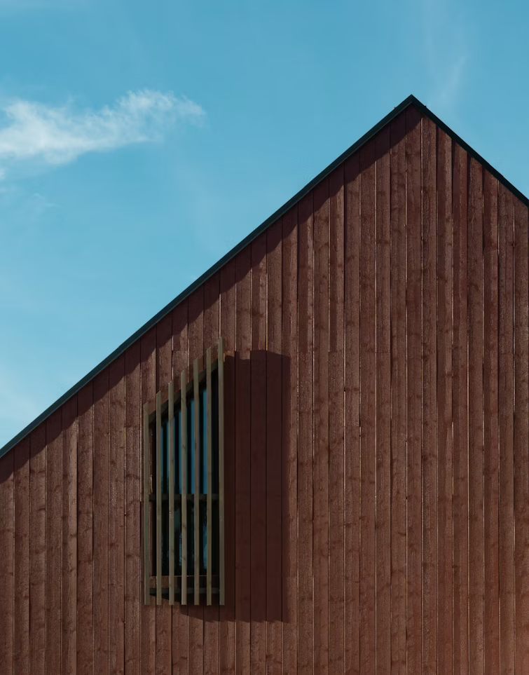 side of wooden house with blue sky behind