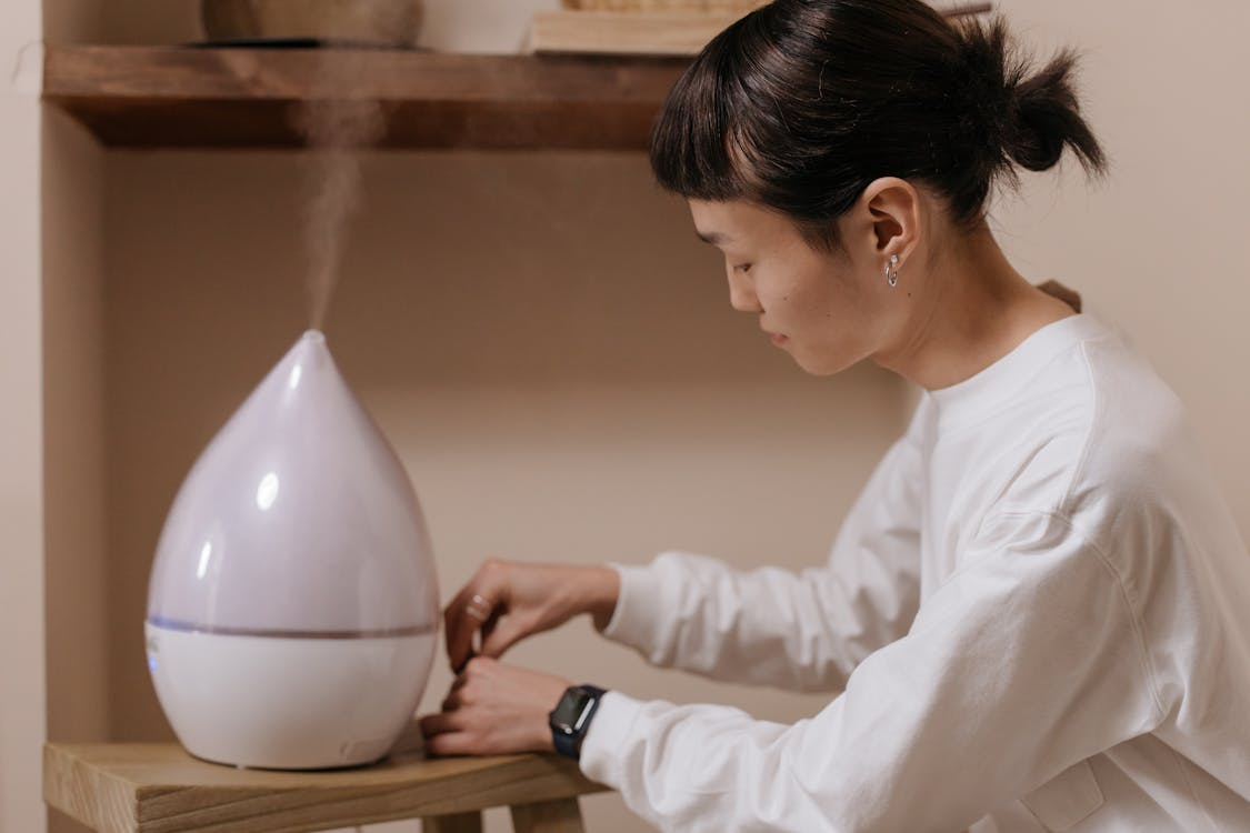 woman sitting down next to a diffuser