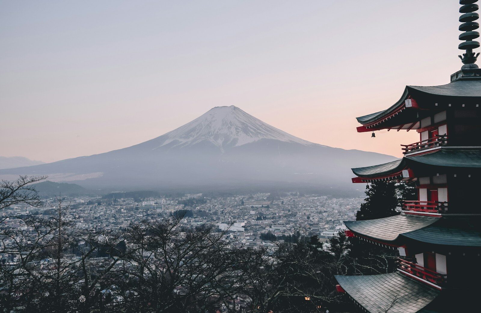 view of Mt. Fuji in Japan from afar, with building nearby and view over city