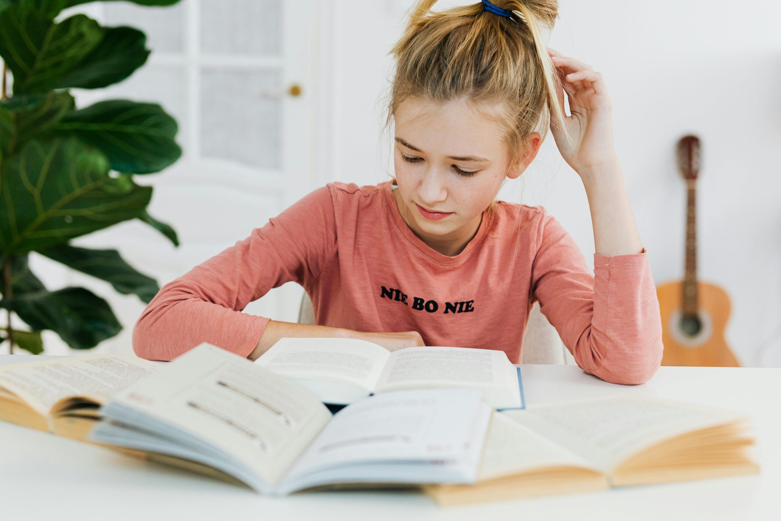 girl sitting at table reading book