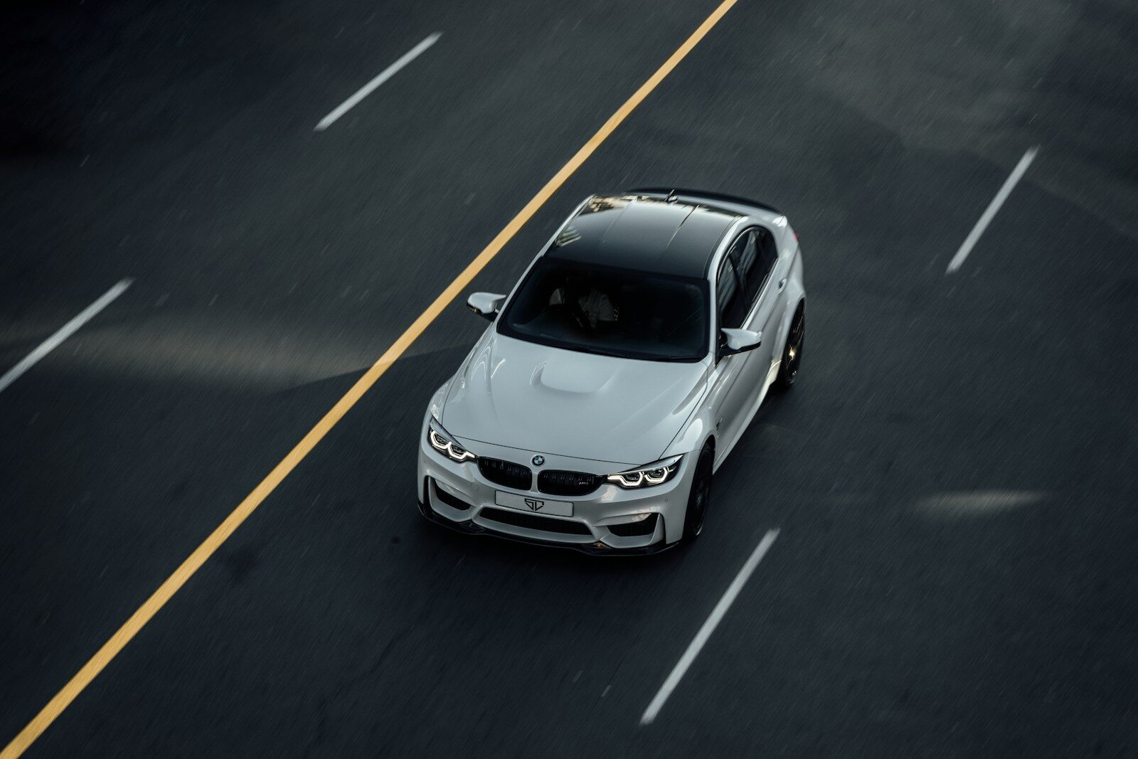 white bmw m3 driving on road