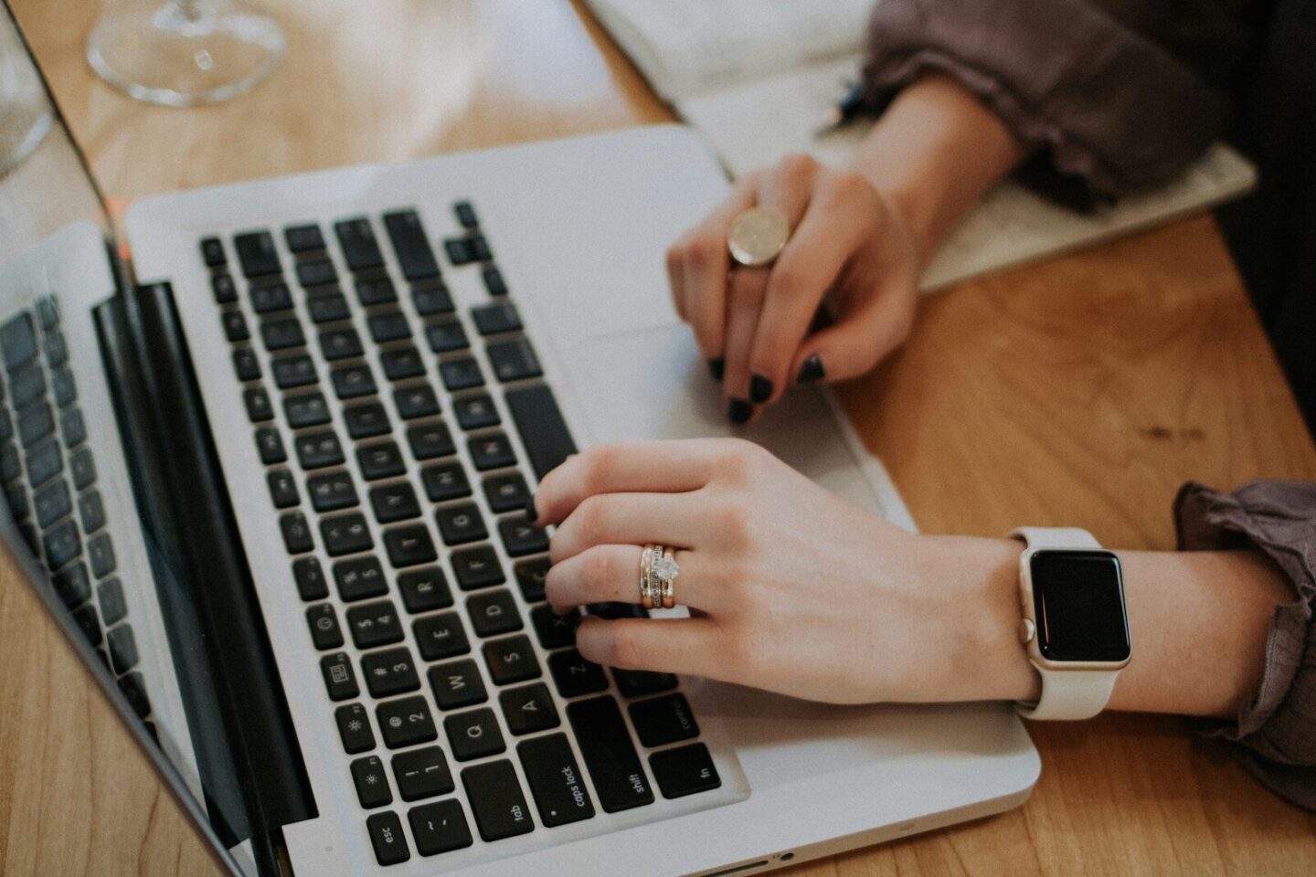woman's hands typing on MacBook