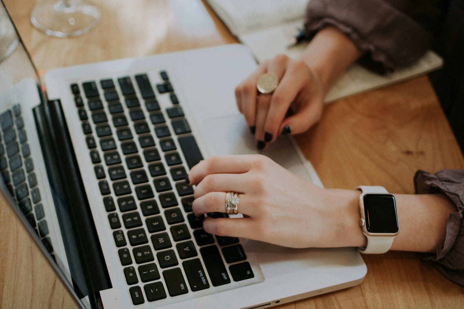 woman's hands typing on MacBook