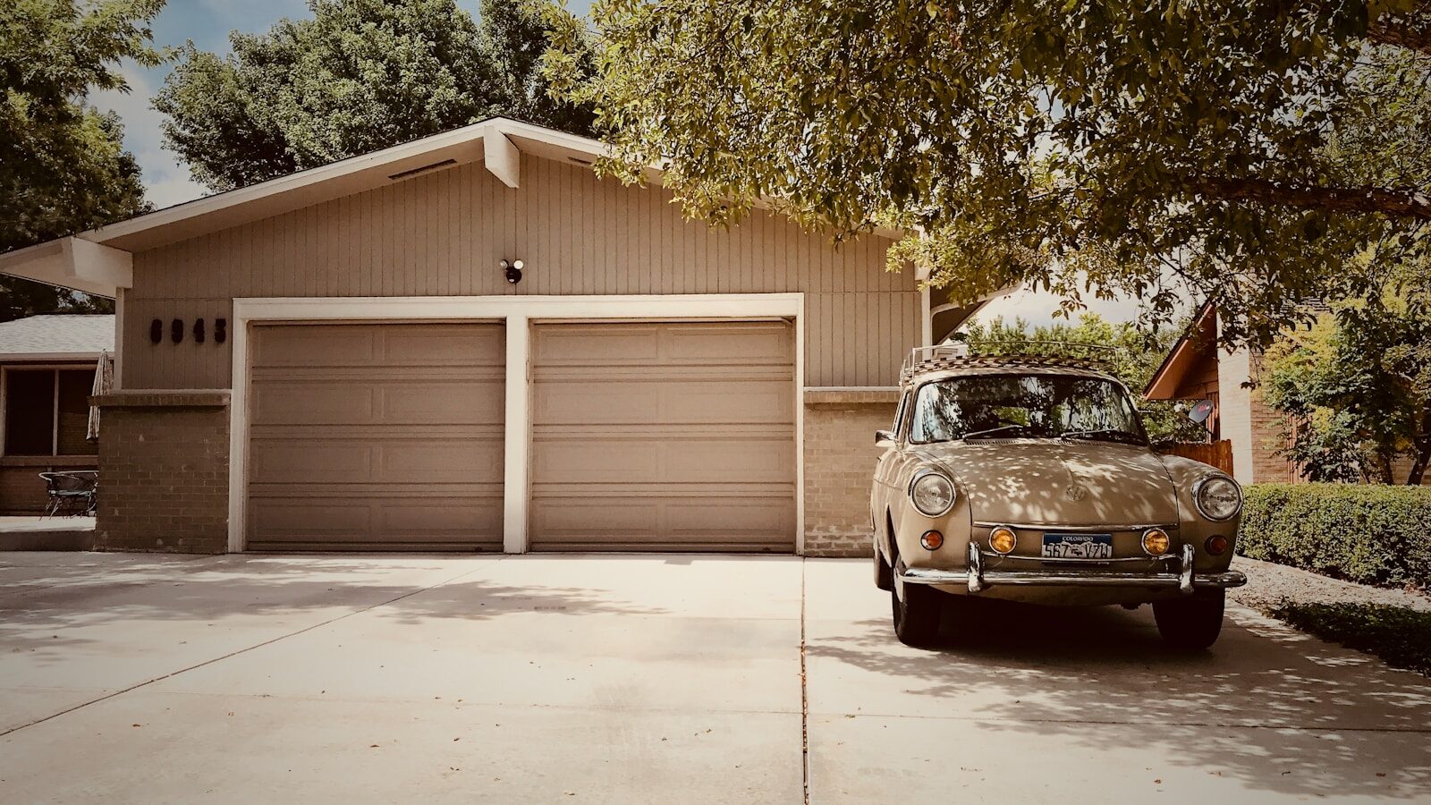 double garage with car parked outside under tree