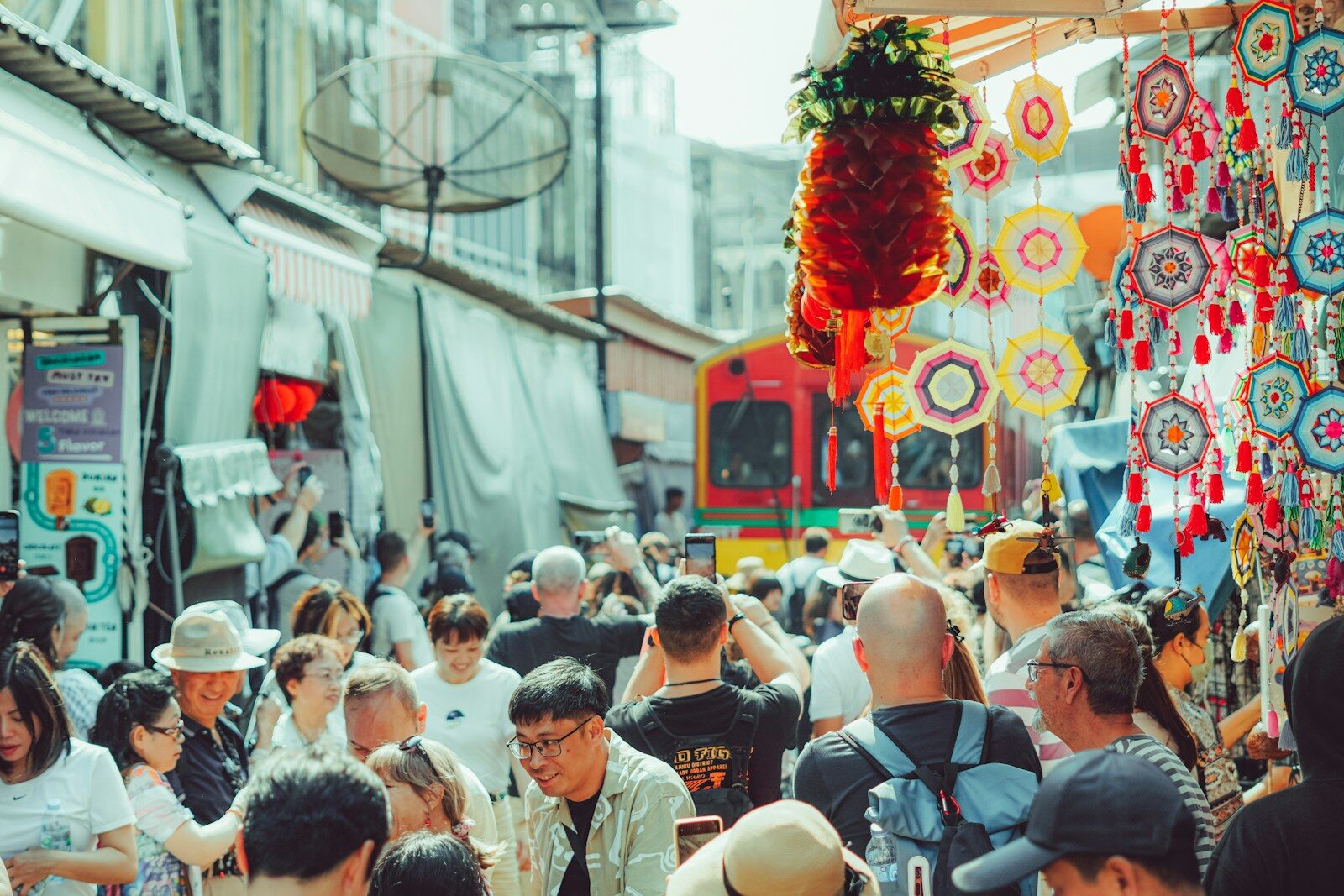 A crowded street with people and colourful decorations