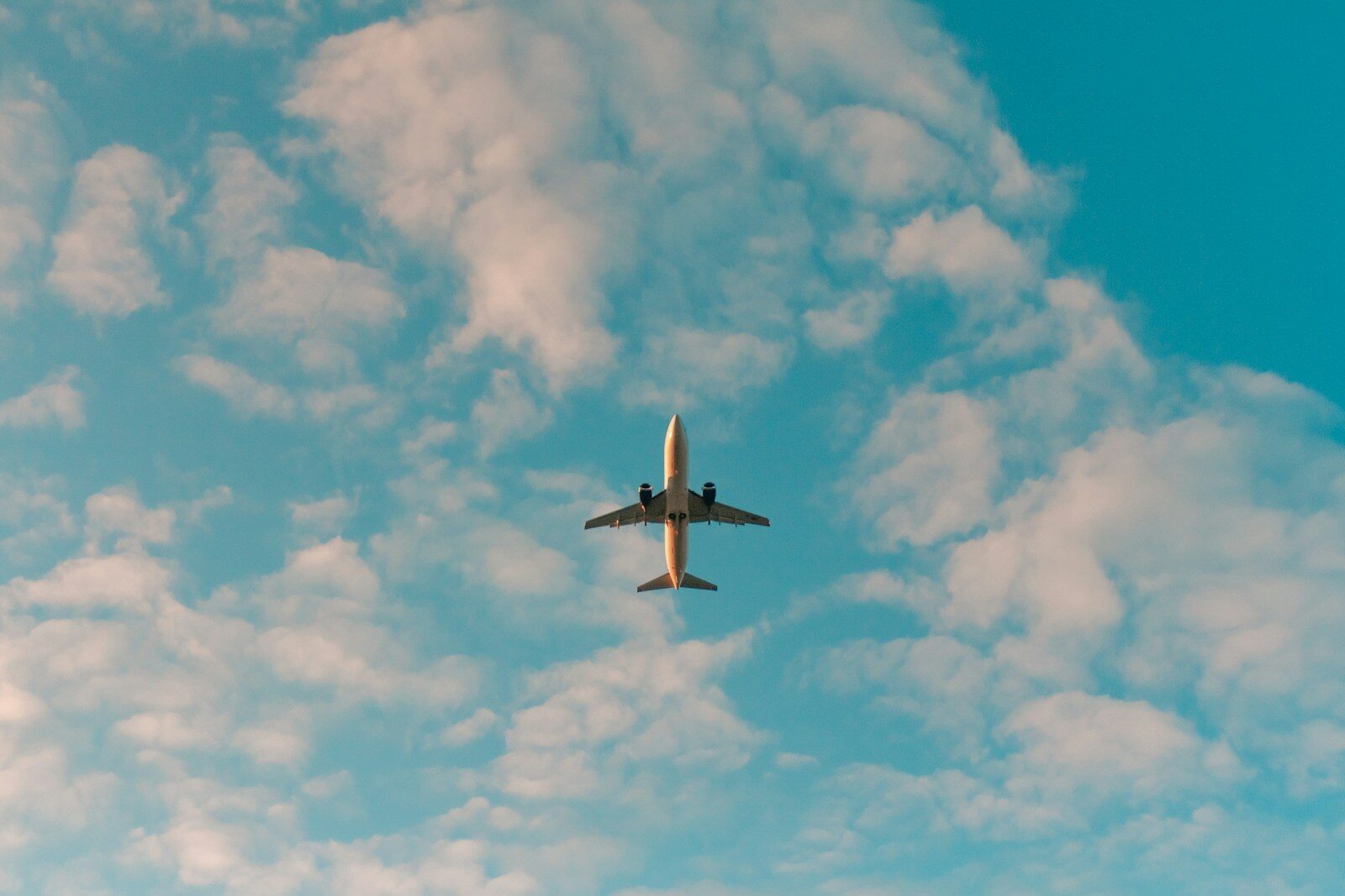 white aeroplane flying in the sky during daytime