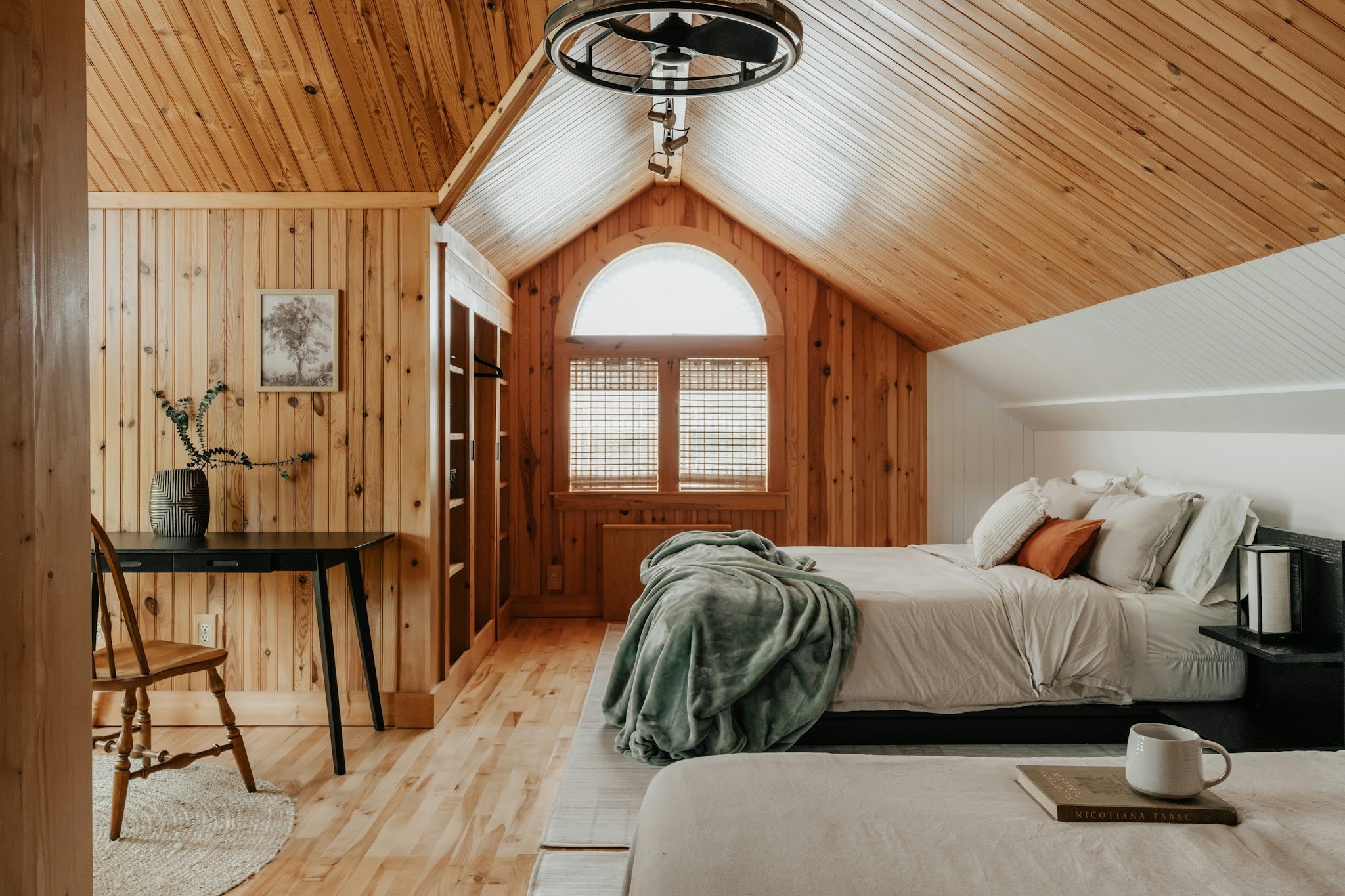large bedroom with wood panelled walls and French doors