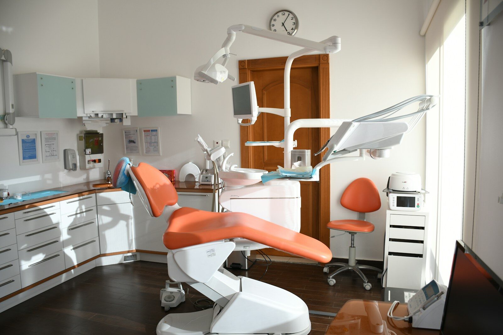 dentist's room with orange chair and equipment