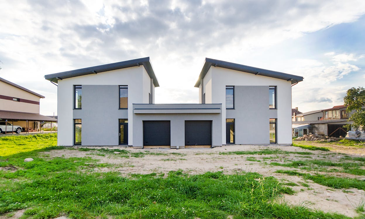 modern house with extension, with patchy grass in front
