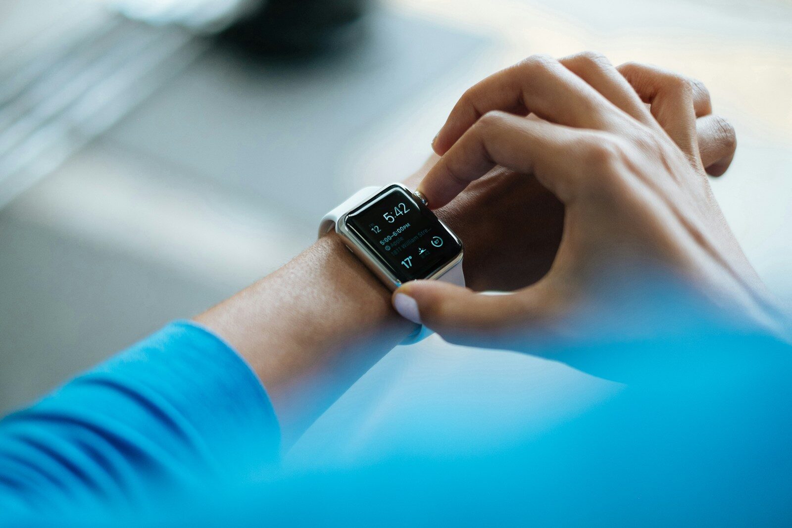 person clicking Apple Watch smartwatch on wrist