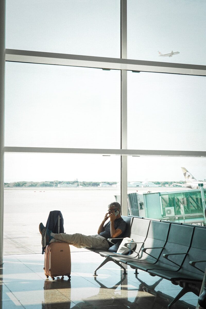 Man talking on phone in airport waiting area