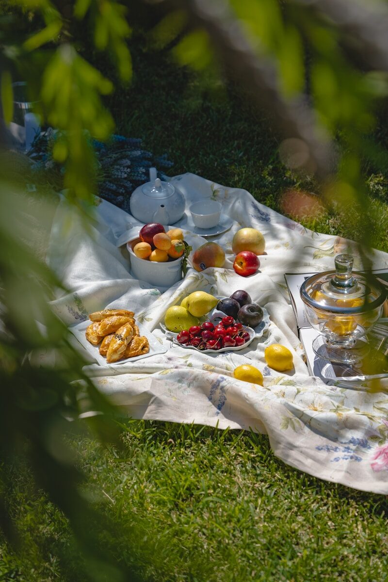 a picnic is set out on a blanket on the grass