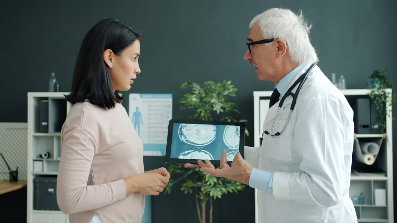 doctor standing in front of woman, showing her a screen
