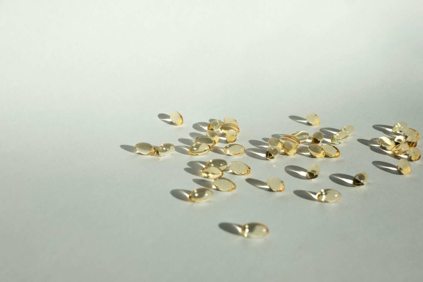 yellow supplement capsules on white surface