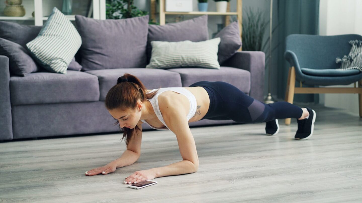 woman doing plank on the floor in living room at home