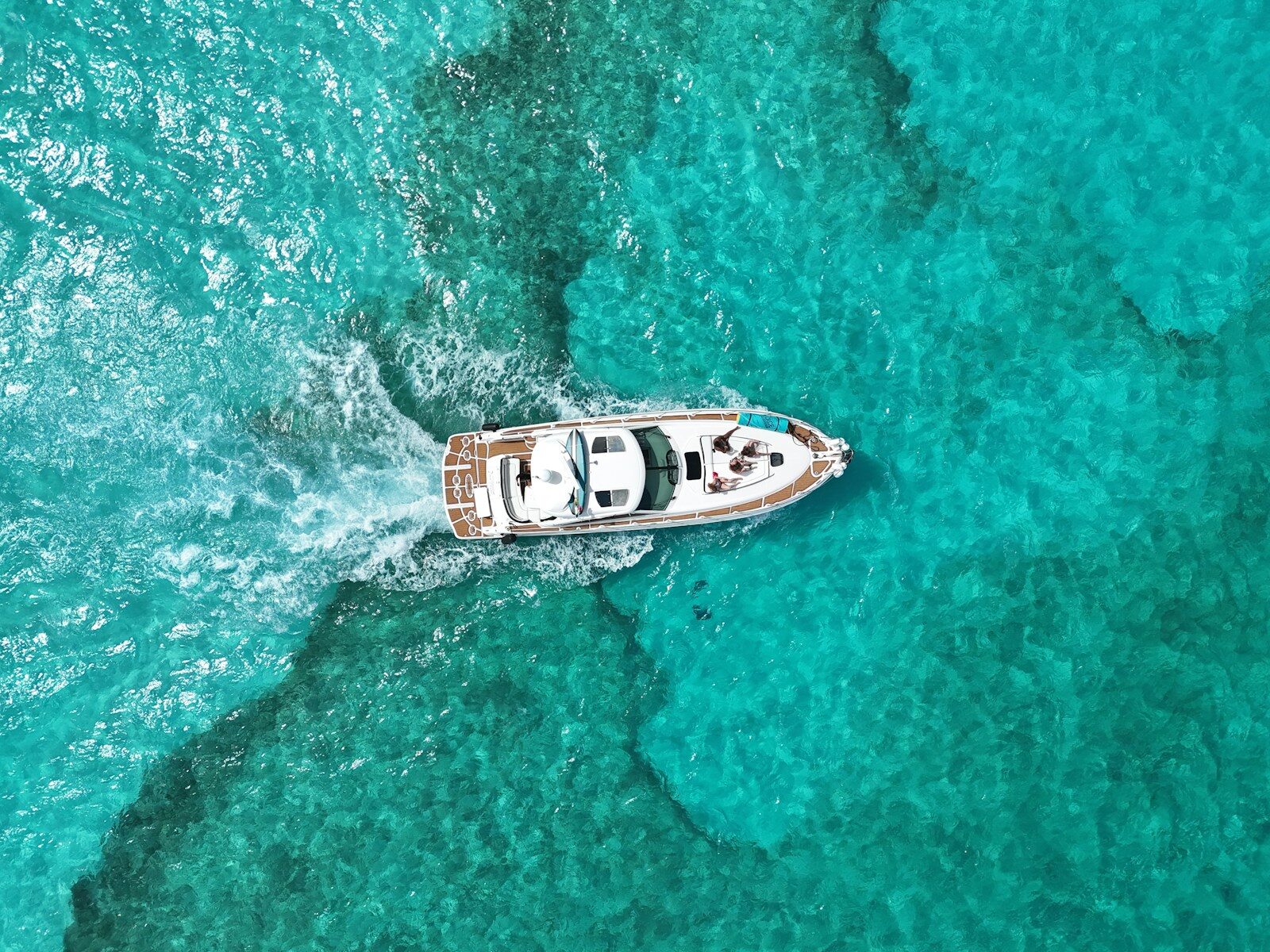 A boat speeds through crystal blue waters