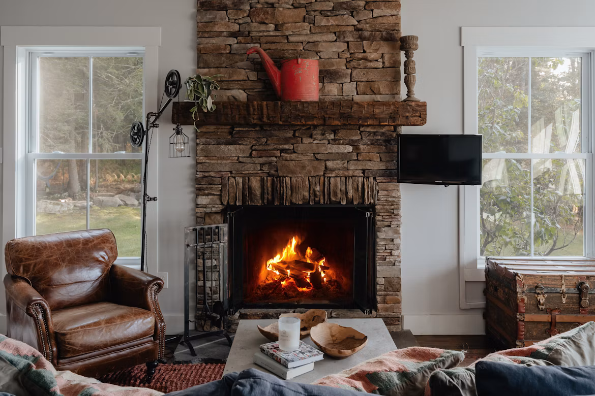 a cosy -looking lounge with a lit fire in the fireplace