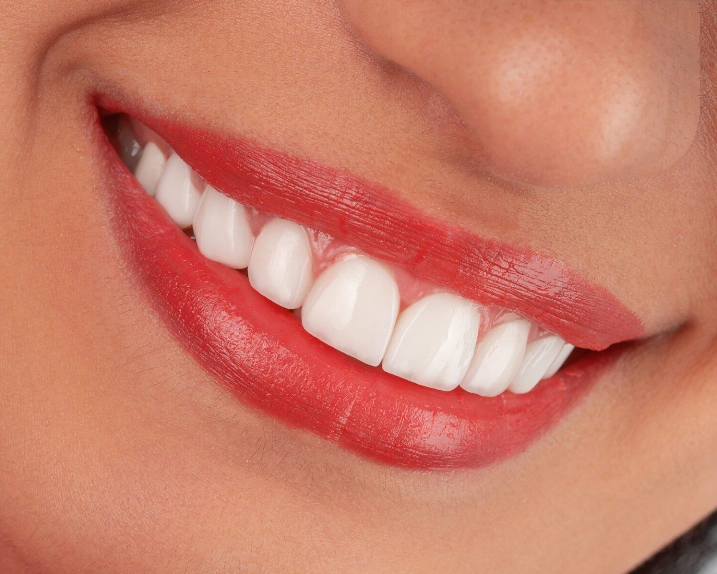 Close-up of a woman's smiling mouth with red lipstick