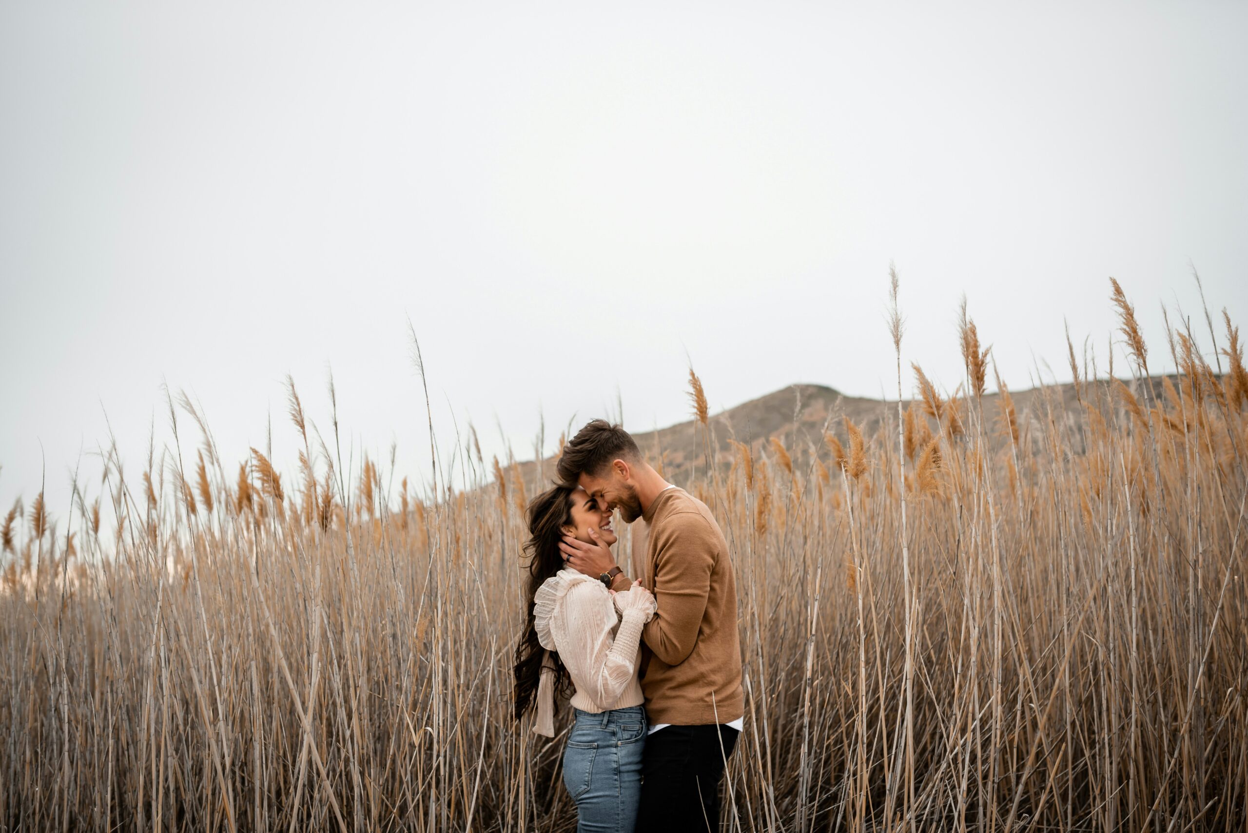 man and woman holding onto each other outside