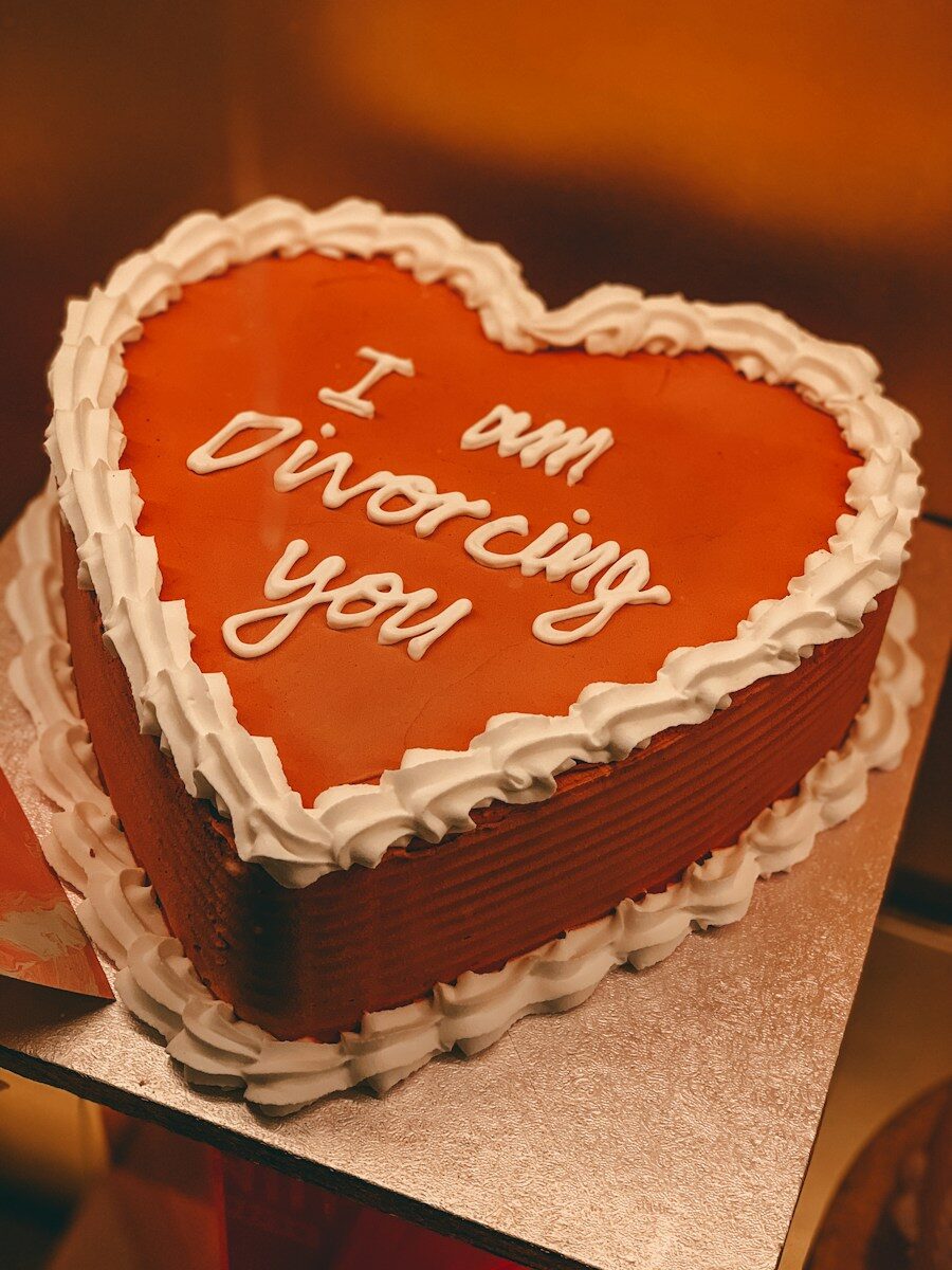 heart-shaped birthday cake with the words 'I am divorcing you' on it