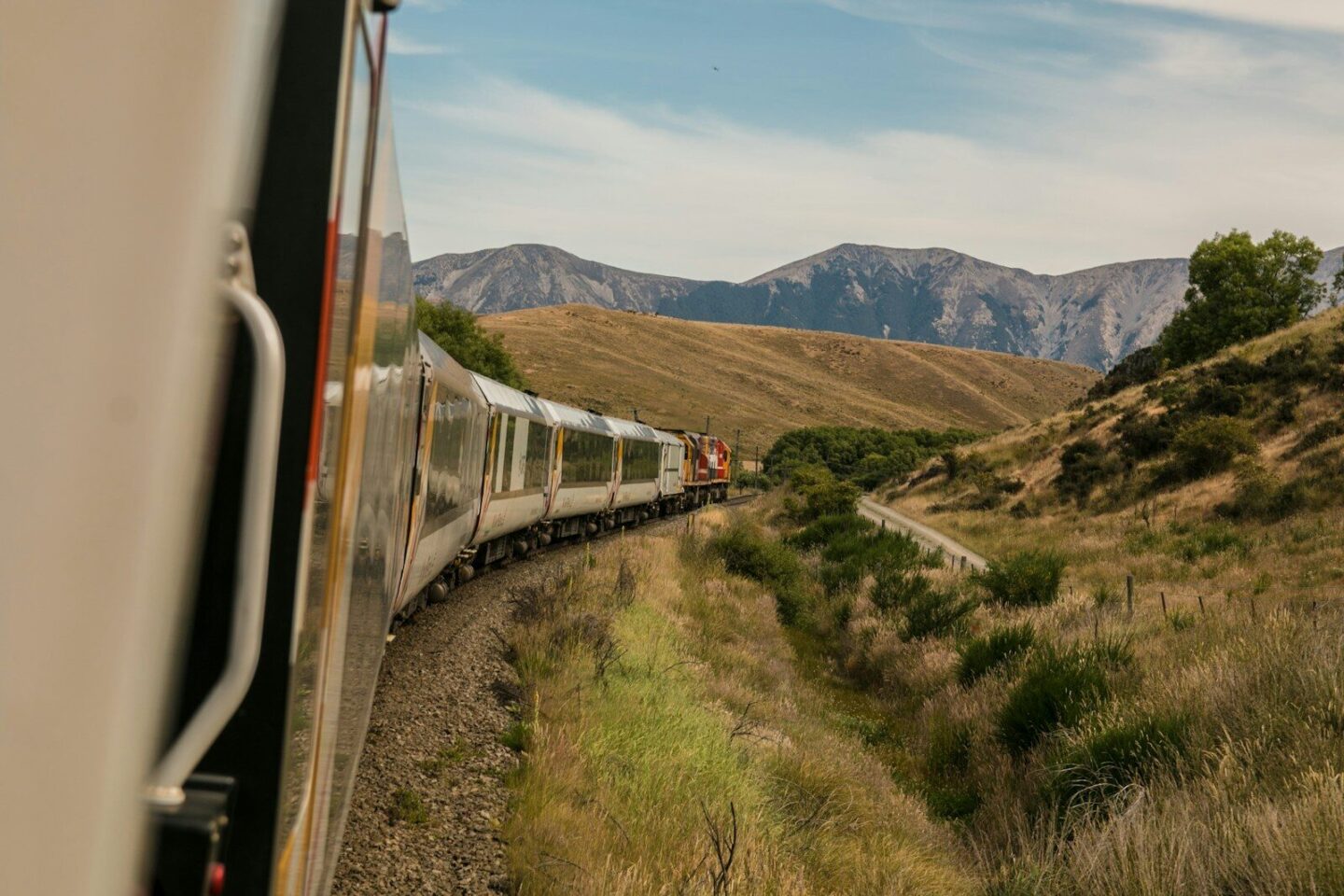 train with the view of mountains in the distance during daytime