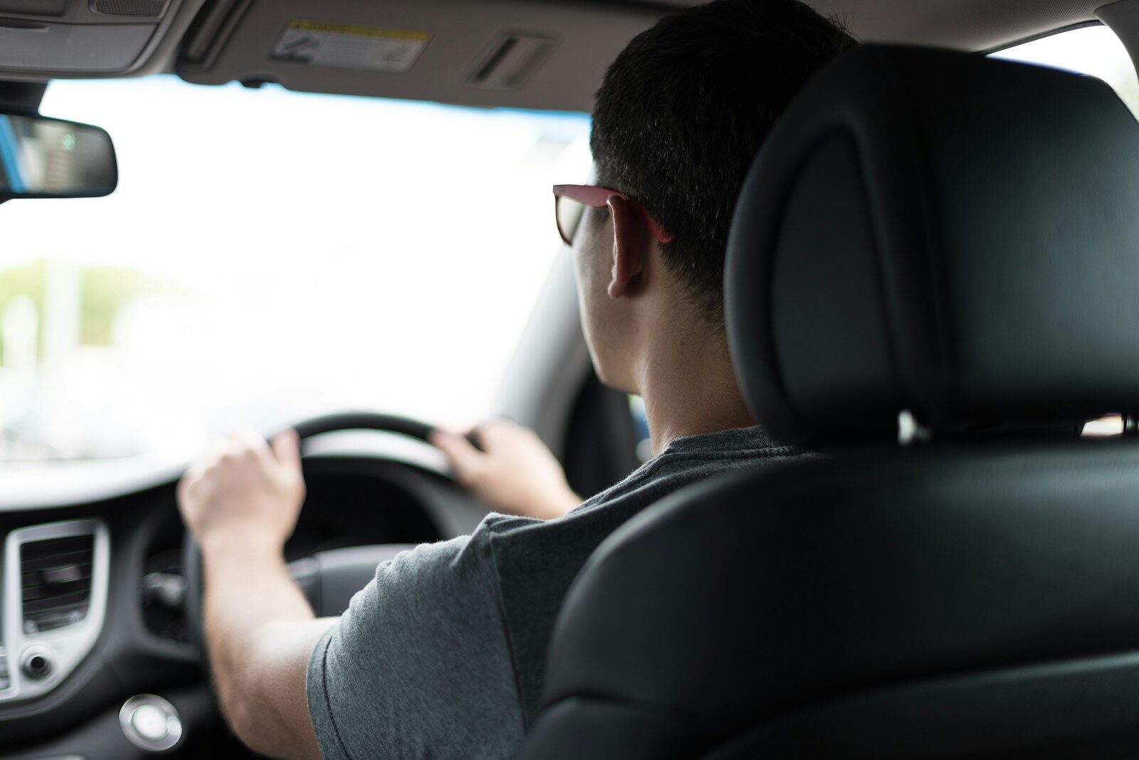 teenage boy driving car during daytime